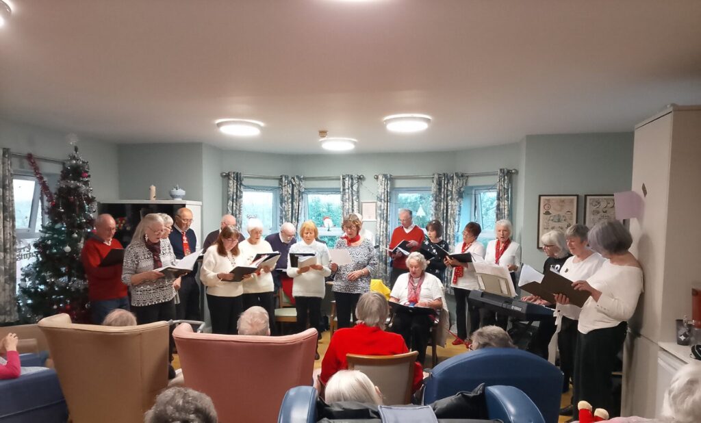 Residents at Ceris Newydd and Glyn Menai singing along during a peaceful Christmas carol service.