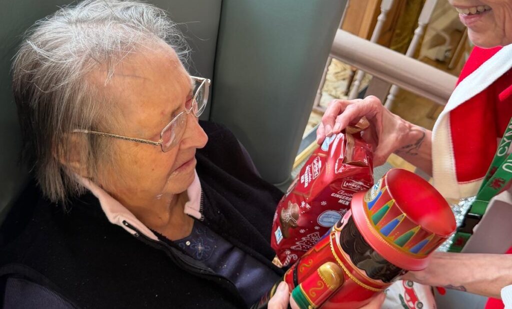Residents and staff at Eryl Fryn sharing gifts and enjoying festive activities on Christmas Day.