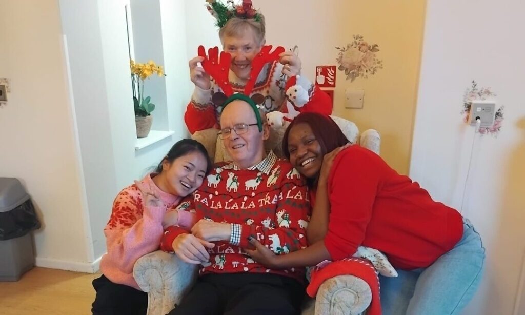 Residents spending quality time with family members during Christmas Day celebrations at Fairways Newydd.
